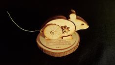 an ornament made out of wood with a mouse on it's back