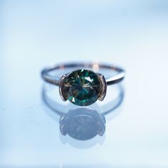 a ring with a green diamond on it