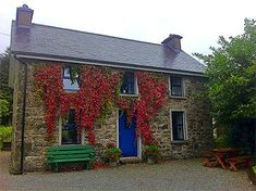 an old stone house with ivy growing on it's walls and blue front door