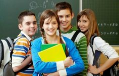 group of students taking selfie in front of chalkboard