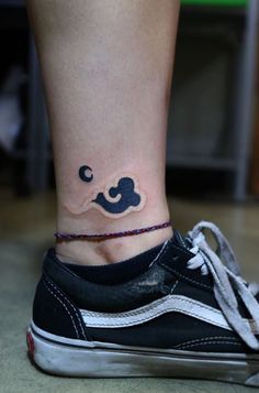 a woman's foot with a small tattoo on the side of her leg and an upside down shoe