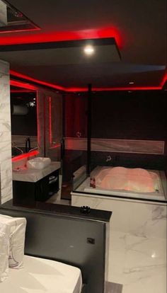 a bathroom with a tub, sink and large mirror in the corner that is lit up by red lights