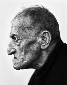 an old man with wrinkles on his face and neck, looking off to the side