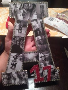 a person holding up a letter made out of photos