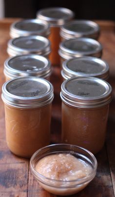 several jars filled with food sitting on top of a wooden table