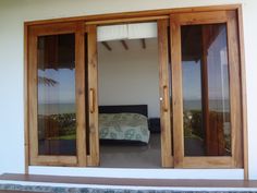 a bedroom with sliding glass doors and a bed in the corner on the other side