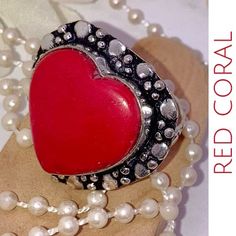 a red coral heart surrounded by pearls