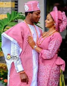 a man and woman dressed in pink standing next to each other