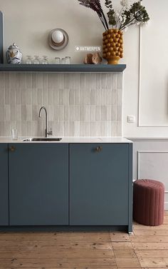 a kitchen with blue cabinets and wooden floors