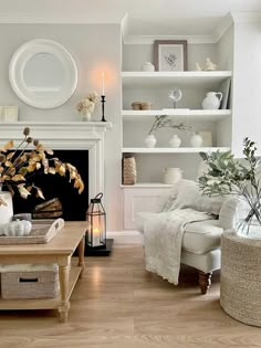 a living room filled with furniture and a fire place in front of a white fireplace