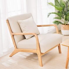 a living room with a chair, table and potted plant