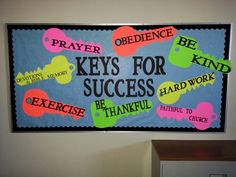 a bulletin board on the wall with words and phrases written in different colors to help students learn