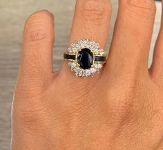 a woman's hand with a diamond and sapphire ring on top of her finger