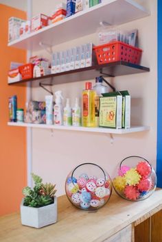 two baskets filled with eggs sitting on top of a wooden table next to a shelf