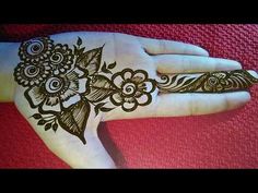 a henna tattoo on someone's hand that is decorated with flowers and leaves