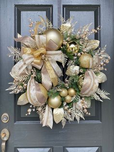 a wreath with gold and silver ornaments hanging on the front door