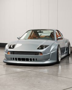 a silver sports car parked in front of a white wall and grey tile flooring