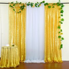 gold sequin curtains with ivy on them and a cake in the middle next to it