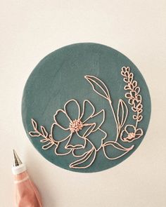 a blue plate with flowers on it next to a pink pen and some other items