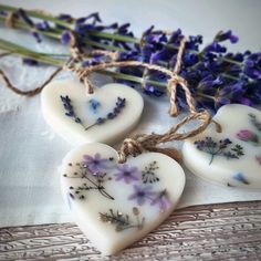 three soaps shaped like hearts with flowers on them sitting next to some twine of twine