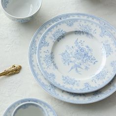 blue and white plates with gold handles on a table