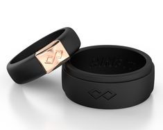 two black rings with rose gold accents are shown in front of each other on a white background