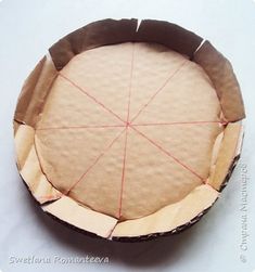 a paper plate with some red thread on it and a piece of cardboard in the middle