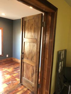 an open wooden door in a room with hard wood floors