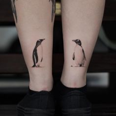 two tattoos on the legs of people with penguins