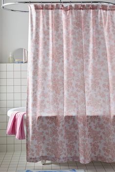 a pink shower curtain in a bathroom next to a white tiled wall and flooring