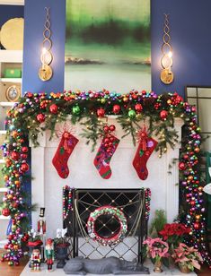 a fireplace decorated for christmas with stockings and wreaths