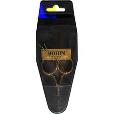 a pair of golden scissors sitting inside of a black box with the word, bohn on it