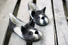 two stuffed animals sitting on top of a wooden bench next to each other, one is gray and the other is white