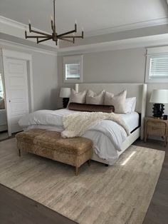 a bedroom with a large bed and white linens