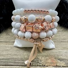 Boho Blush Bracelet Stack – where the enchanting hues of rose gold and pristine white hues come together in a whimsical dance of elegance and boho charm. This stack isn't just jewelry; it's a serenade to your free-spirited soul. Treat yourself with the Boho Blush Stack and let each bracelet tell a tale of carefree grace. So Pretty!! Wear them all on one wrist and stack 'em up or wear 3 on one wrist and two on the other with a watch! Lead & Nickel Free Bracelets are 'one size fits most' and are designed to fit wrists up to 7.5" comfortably Stretch bracelets set of 5 Off White and Rose Gold Hues Pave Crystal Embellishment Heart Charm with Leather Fringe Pull Please be aware that due to the unique and handmade nature of each product, colors, shapes, and bead sizes may vary slightly from the p Trendy Rose Gold Beaded Bracelets For Party, Adjustable Rose Gold Charm Bracelet For Parties, Rose Gold Stackable Beaded Bangle Bracelets, Bohemian White Charm Bracelet With Round Beads, Bohemian Charm Bracelet With White Round Beads, Adjustable Stackable Rose Gold Bracelets, Rose Gold Beaded Bangle Bracelets For Party, Rose Gold Beaded Bangle Bracelet For Party, Rose Gold Bangle Beaded Bracelets For Party