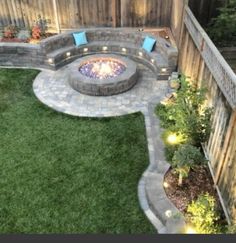 an outdoor fire pit surrounded by green grass