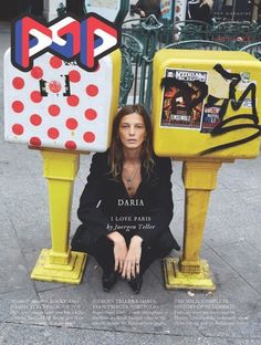 a woman sitting on the ground next to two yellow mailboxs with red and white polka dots