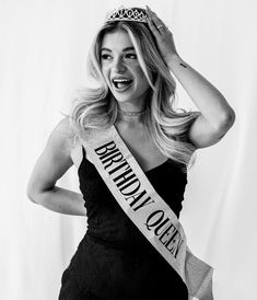 black and white photograph of a woman wearing a crown with her hands on her head