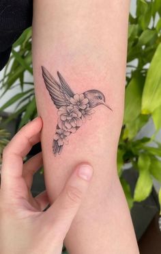 a small hummingbird tattoo on the arm