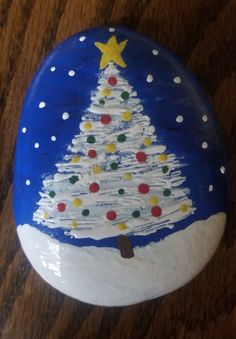 a painted rock with a christmas tree on it