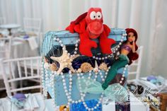 the little mermaid cake is decorated with pearls and seahorses as well as other decorations