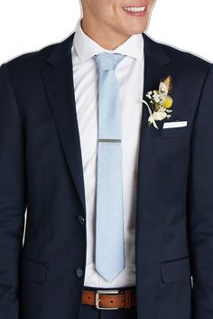 a man wearing a suit and tie with a boutonniere on his lapel