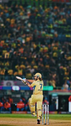 a man in yellow uniform playing a game of cricket