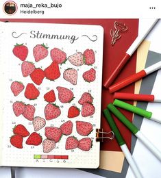 an open notebook with strawberries on it