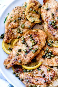 chicken with lemons and capers on a white plate, ready to be eaten