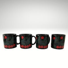 four black and red coffee mugs sitting next to each other