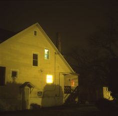 the house is lit up at night with no one in it's yard or yard