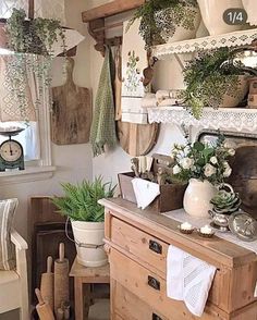 an old fashioned kitchen with pots and pans on the stove top, potted plants