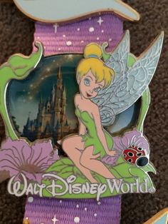 the disney world marathon medal has a fairy sitting on it's back with a lady bug