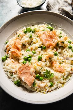 a white bowl filled with rice and peas on top of a table next to other dishes